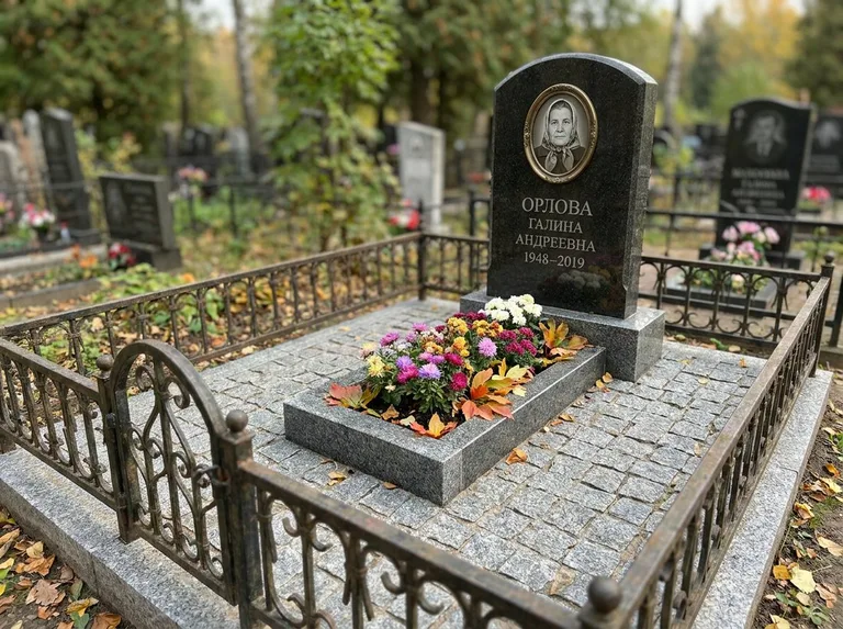 Благоустроенное захоронение с гранитной плиткой, оградой и цветником в Новокузнецке