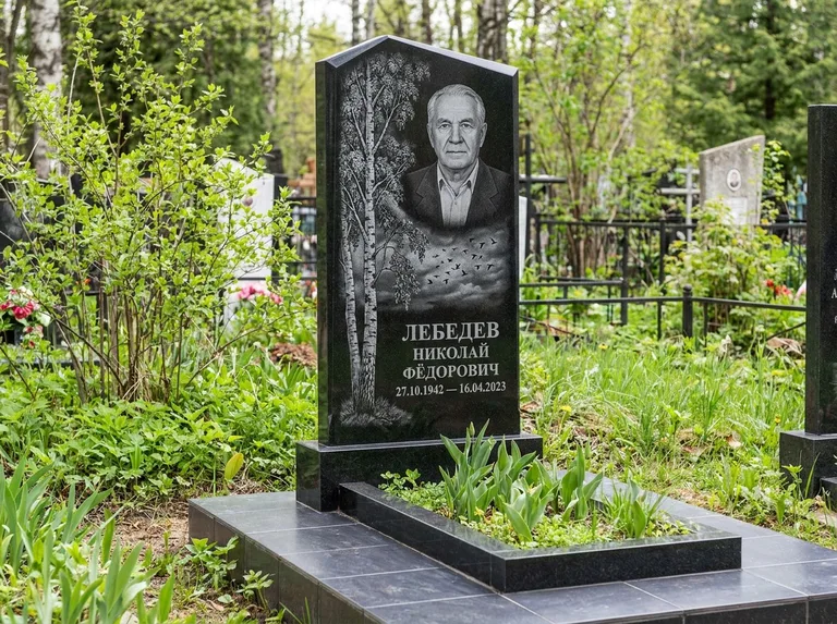 Памятник с гравировкой берёзы: вертикальная стела со скошенным верхом — берёза и стая птиц в небе, гранитный цоколь с тёмной плиткой, работа «Лебедев» в Новокузнецке