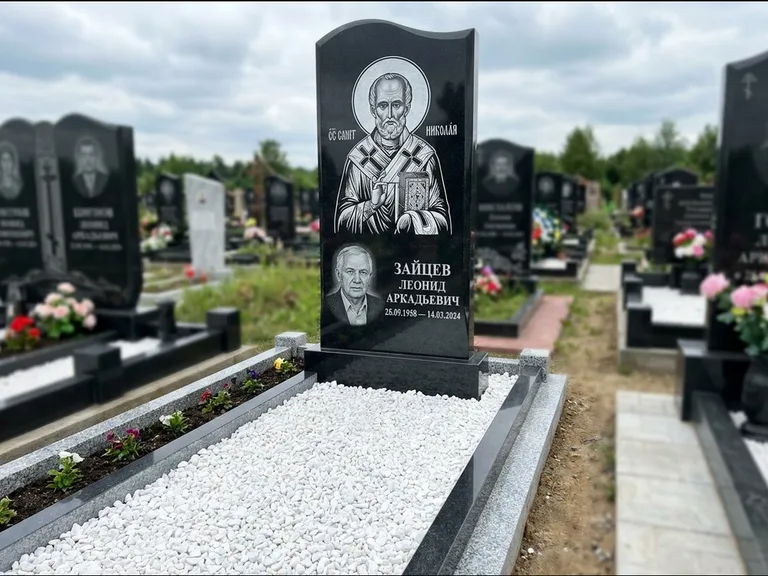 Памятник с гравировкой иконы: стела с крестообразным навершием — икона в резной рамке-киоте, газон без ограды, стриженая трава, работа «Раевская» в Новокузнецке
