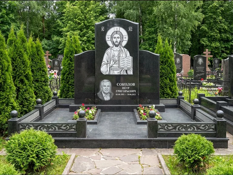 Памятник с гравировкой иконы: широкая горизонтальная лежачая плита-стела — икона в резной рамке-киоте, серая гравийная отсыпка с бордюром, работа «Богданова» в Новокузнецке