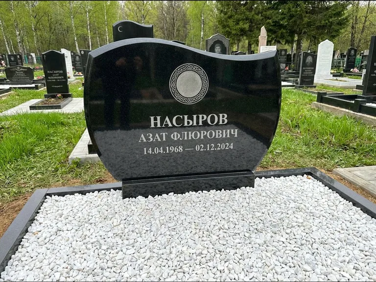 Мусульманский памятник: стела с волнообразным скошенным верхом — гравировка мечети под полумесяцем и звёздами, белая мраморная крошка с бордюром, работа «Насыров» в Новокузнецке