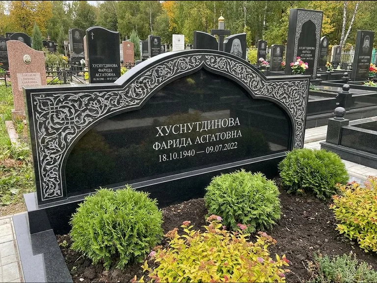 Мусульманский памятник: вытянутая горизонтальная семейная стела с аркой — белая гравировка силуэта мечети с минаретами, участок с декоративными кустами, работа «Зарипова» в Новокузнецке