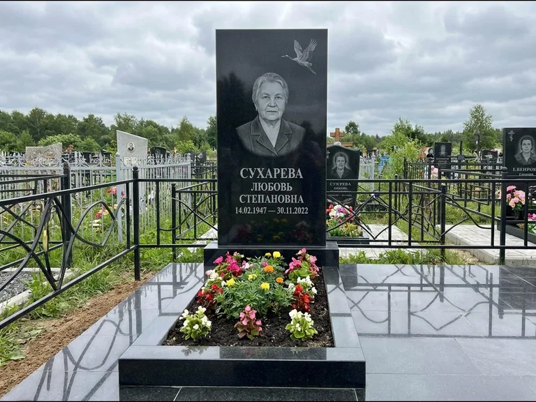 Памятник с гравировкой журавлей — гравировка одиночного летящего журавля над портретом, работа «Сухарева» в Новокузнецке