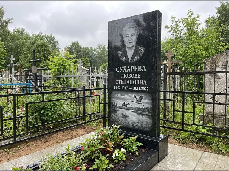 Памятник с гравировкой журавлей — гравировка пары журавлей над гладью озера в нижней части, работа «Сухарева» в Новокузнецке